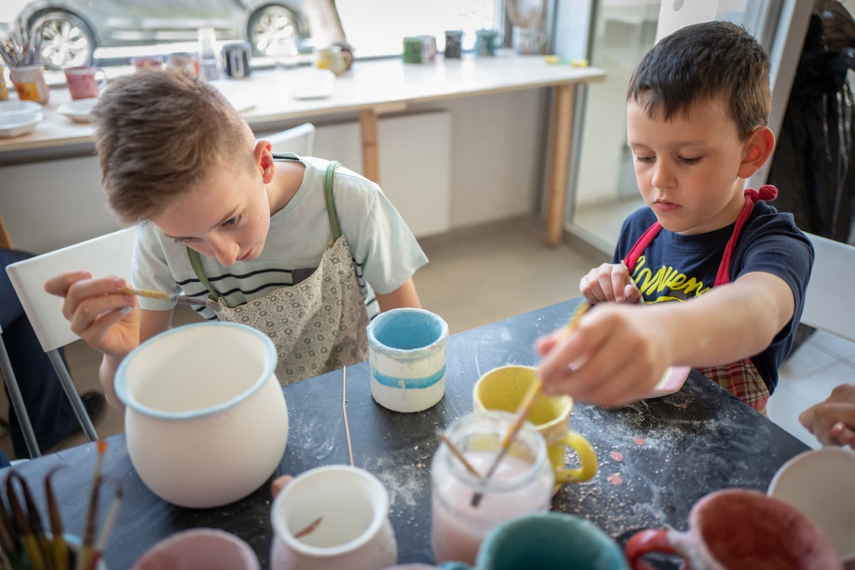 Caucasian Boys Painting Pottery